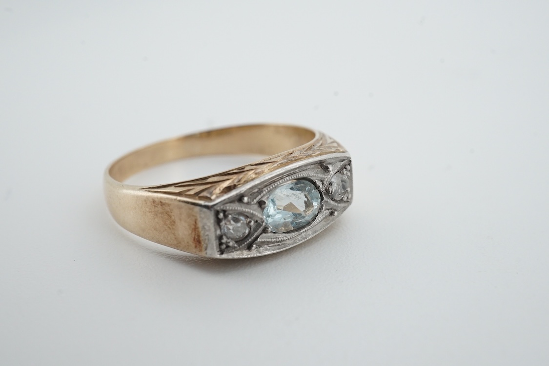 A mid 20th century yellow metal (stamped 585), aquamarine and diamond set three stone ring, size 0, gross weight 4.6 grams.